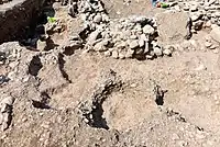 Part of the surface of one of the adjacent outdoors. The area has been punctuated by modern looters' pits.