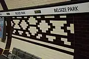 The complete design in the repeated platform frieze. As part of the station upgrade the platform tiling was replaced although the tone of the new tiles is darker than the originals.