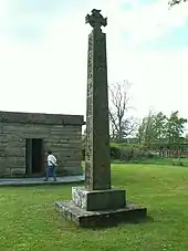 Replica of the Bewcastle Cross in the churchyard of St Mary's church, Wreay; the mausoleum of Katharine Losh is behind