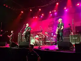 Face to Face performing at the Fillmore Auditorium in Denver, 2022
 Left to right: Shiflett, Keith, ex-drummer Parada (behind drum kit), and Hill.