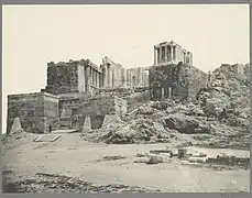 Black-and-white photograph of the gate, from a distance, showing the Temple of Athene Nike above