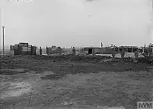 Cut outs that resemble British soldiers and tanks are arrayed across the center of the photograph.