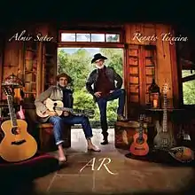 Foto da capa do álbum AR na qual estão Almir Sater (sentado à esquerda) e Renato Teixeira (em pé)