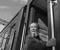 A black-and-white image of Aleksandr Solzhenitsyn outside a building.