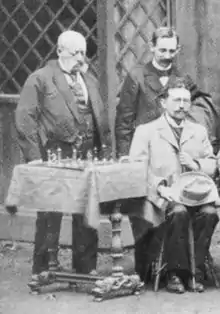 Participantes do Torneio de Xadrez de Viena de 1898: Adolf Schwarz (à esquerda), Carl Schlechter (à direita), Siegbert Tarrasch (sentado).