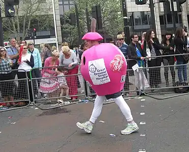 Corredor fantasiado de maçã disputa a maratona.