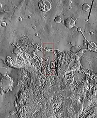 Imagem em vista ampla da THEMIS das seguintes imagens da HiRISE. O quadrado preto mostra a localização aproximada das imagens da HiRISE.  Essa imagem é apenas parte de uma vasta área conhecida como Aureum Chaos.  Clique na imagem para visualizar detalhes.