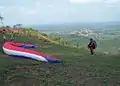 Atleta de voo livre em parapente, decolando da Serra do Estrondo, ao fundo a cidade de Axixá do Tocantins.