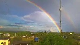 Um arco-íris sobre a cidade, com a Serra da Bela Adormecida ao fundo.