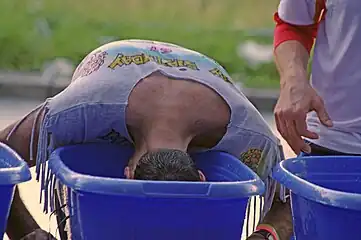 Corredor refresca a cabeça numa das tinas d'água ao longo do percurso.