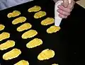 Modelando a massa choux com o bico de confeiteiro para a preparação de beignets