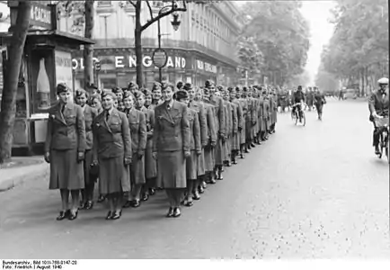 No início da ocupação alemã, em agosto de 1940, sinaleiras auxiliares desfilando no Boulevard des Capucines (ao fundo, a loja Old England, uma das placas emblemáticas da artéria, de 1867 até seu desaparecimento em março de 2012)