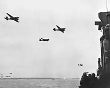 Aeronaves de transporte Douglas C-47 Skytrain da Força Aérea dos EUA voam baixo sobre uma LCI (L) da Guarda Costeira dos EUA na praia de Utah.