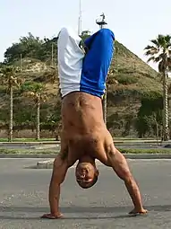 Com as pernas dobradas na capoeira