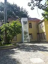 Fundo da Chácara Lane, onde se vê um elevador e o estacionamento