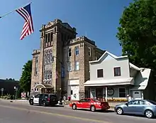 Edifício Municipal de Colfax (edifício maior à esquerda) em Colfax, Wisconsin, foi construído em 1915 e abrigava a delegacia de polícia, estação de bombeiros, salas de reunião, auditório, salão de banquetes e biblioteca da cidade.