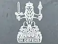 Crista das (históricas) Armas Reais da Escócia e das Armas Reais do Reino Unido usadas na Escócia; o leão do rei dos escoceses no topo da coroa da Escócia, portando as honras da Escócia. Lema: EM DEFESA