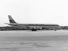 Uma fotografia em preto e branco de uma aeronave Douglas DC-8 na pista