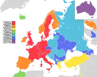 Mapa de países da Europa, Norte da África e Ásia Ocidental, com a Austrália como inserção no canto superior direito, colorido para indicar a década em que eles participaram pela primeira vez do concurso: 1950 em vermelho, 1960 em laranja, 1970 em amarelo, 1980s em verde; Década de 1990 em azul celeste; 2000s em azul; e 2010 em roxo