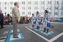 A tripulação se despede da direção da Roskosmos na cerimônia antes do embarque.