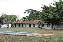 A fotografia mostra a área posterior do terreno da Casa Niemeyer, parte de seu jardim e de sua piscina.