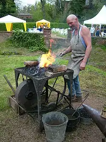 Um Cuteleiro (Ferreiro) trabalhando em sua Forja