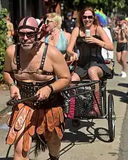 Homem puxando uma carroça com uma dominatrix