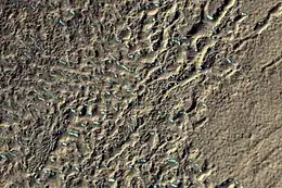 Superfície de uma plataforma de detritos em Terra Cimmeria, visto pela HiRISE, sob o programa HiWish.  Partes coloridas podem ser depósitos de gelo.