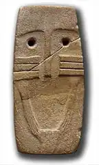 Ídolo com os olhos ressaltados por incisões verticais.Possui braços estilizados