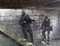 Soldados da Bundeswehr usando um fuzil G36 e uma HK P8 em um exercício militar.