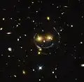 "Imagem de Smiley" – aglomerado de galáxias (SDSS J1038+4849) & lente gravitacional (um anel de Einstein) (Hubble).