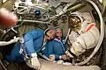 Cosmonautas Suraev e Kotov checam traje para caminhada espacial.
