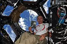 Na Cúpula da ISS, o astronauta Andrew Feustel posando contra a Terra ao fundo, segura uma cópia do desenho "Paisagem Lunar" feita durante a II Guerra Mundial pelo menino judeu tcheco Petr Ginz quando era prisioneiro do campo de concentração de  Theresienstadt, na Tchecoslováquia.