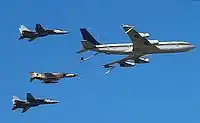 Um avião cargueiro Boeing 707 da força aérea do Irã voando com dois F-14 e um F-4.