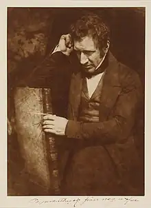 Retrato de James Nasmyth sentado de lado em uma cadeira com o braço apoiado a cabeça.