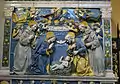 Relevo em terracota por Giovanni della Robbia, onde se mostra Cristo Menino como parte da Divina Trindade, adorado por Maria, José e santos Franciscanos.