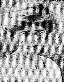 A grainy newspaper photo of a woman in her early 20s who looks straight at the câmera. Her hair is coiffed, and she is wearing a white blouse