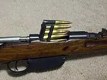 Um clipe em bloco calibre 8×56mmR é inserido em uma carabina Steyr M95.