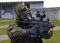 Policial do Ministério da Defesa com uma MP7-SF em traje CBRN.