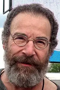 Mandy Patinkin olhando para a câmera.