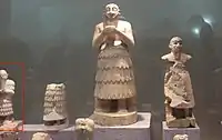 Estátuas de Mari. A estátua de Isqui-Mari aparece parcialmente à esquerda: é muito menor do que muitas das estátuas tradicionais de Mari. Museu Nacional de Alepo