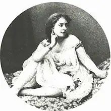 Young woman with dark hair and moderately revealing pseudo-Ancient-Greek costume