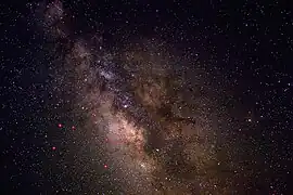 Uma visão do céu noturno perto de Sagittarius, aprimorada para mostrar melhor contraste e detalhes nas faixas de poeira. As principais estrelas em Sagittarius são indicadas em vermelho