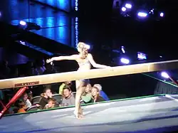 Nastia Lukin praticando uma coreografia no solo na prova da trave olímpica.