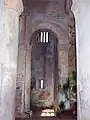 Interior de San Miguel de Lillo, depictando o início da arcada incompleta da arruinada nave sul.