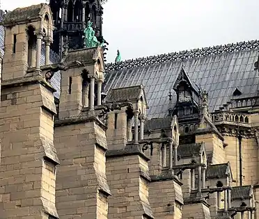 Na Notre-Dame de Paris, os contrafortes maciços se contrapõem ao impulso externo das abóbadas em cruzaria da nave.