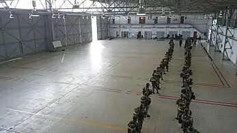 Paraquedistas equipados para salto, aguardando a ordem de embarque.