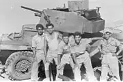 Soldados do Palmach (Brigada Yiftach) com um carro blindado do exército jordaniano, recém destruído por um PIAT, na Operação Dani, em al-Burj, 15 de julho de 1948