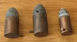 Três exemplares de cartuchos com espoletas internas acionadas por pinos.