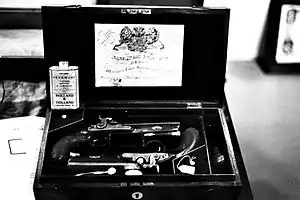 Um dos últimos modelos de pistolas de duelo inglesas disparadas por espoleta de percussão, com o Mandado Real associado ao produto.